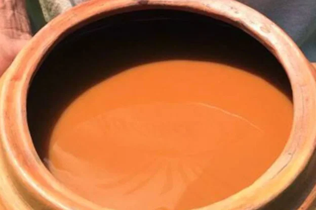 Cuenco de barro tradicional lleno de la infusión espesa de Ayahuasca, lista para ser tomada durante un ritual o ceremonia.