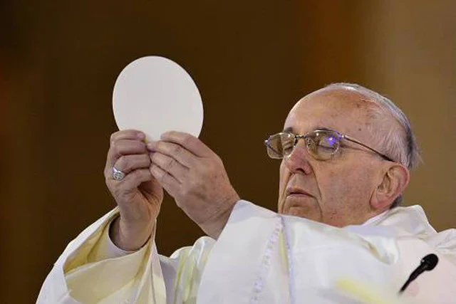 El Papa Francisco alzando la Hostia Consagrada durante una misa, ilustrando el origen religioso y positivo de la expresión popular "ser la hostia".